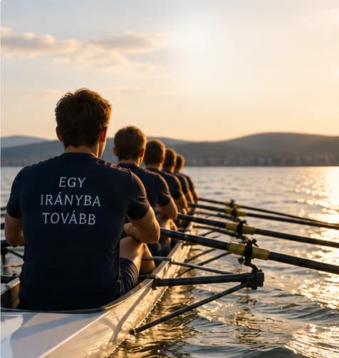 Perahu dayung delapan pedayung tampak dari belakang saat matahari terbenam di Danau Balaton; kaus pedayung terdepan bertuliskan EGY IRÁNYBA TOVÁBB