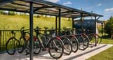 Tempat parkir sepeda beratap dengan deretan sepeda yang terparkir