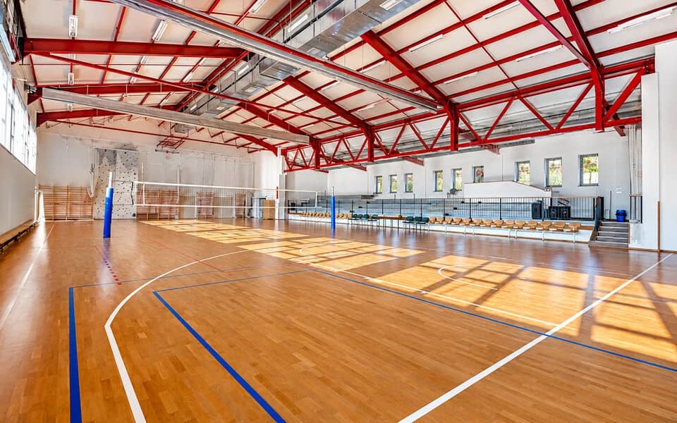 A felújított sportcsarnok belülről, a pályán röplabdázó diákokkal, háttérben a lelátóval