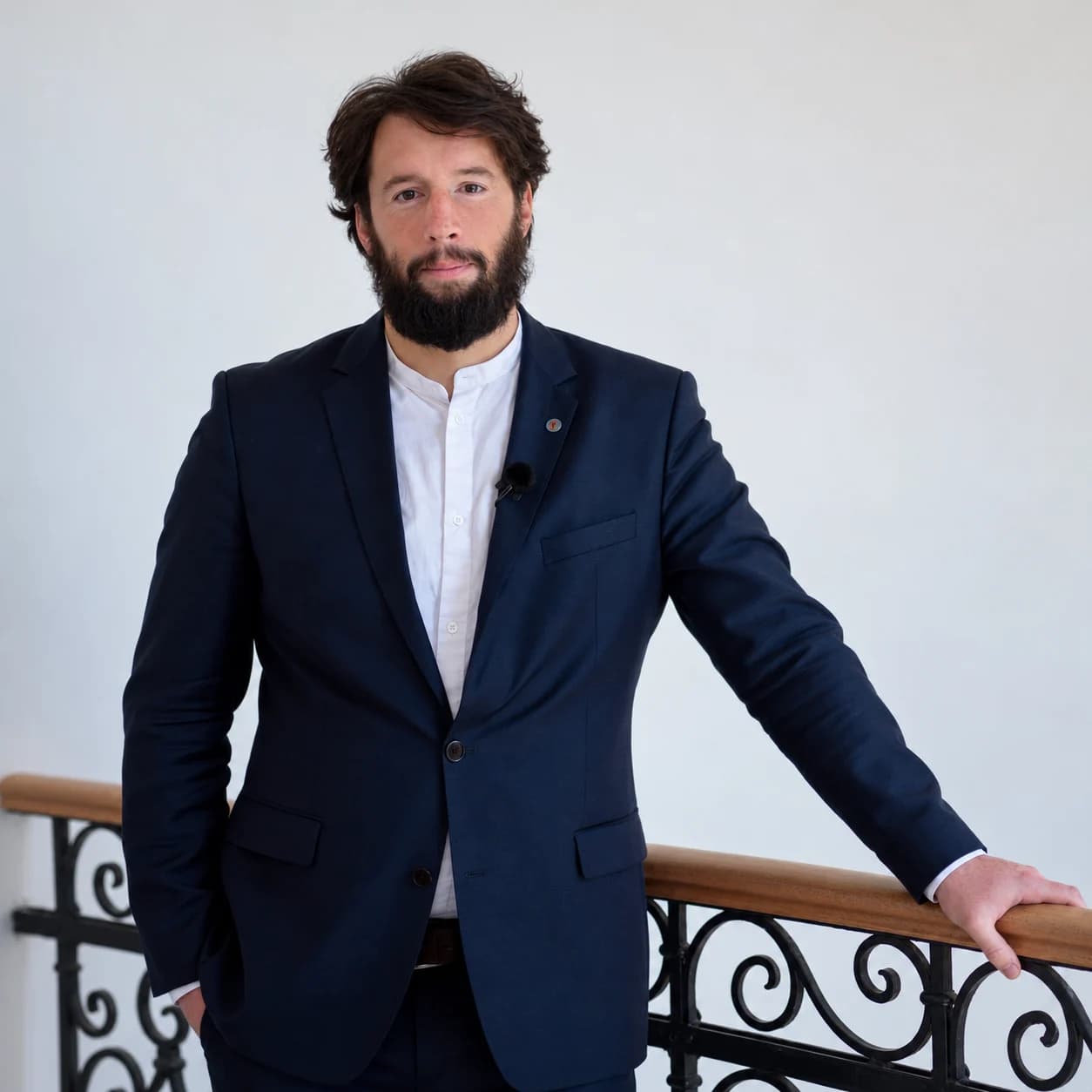Világos mészkő árkád faragott fejezetű ikeroszlopokkal és bordás boltívekkel, mögöttük kilátás a párás, erdős völgyre; a jobb oldali kőfalba vésve: Hagyomány, Felelősség, Közösség, Fejlesztés, Jövő